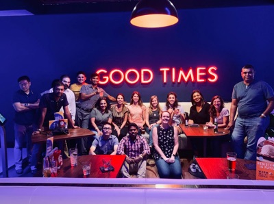 Team of people behind a good times sign