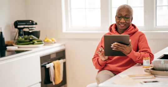 Senior women using iPad in her kitchen