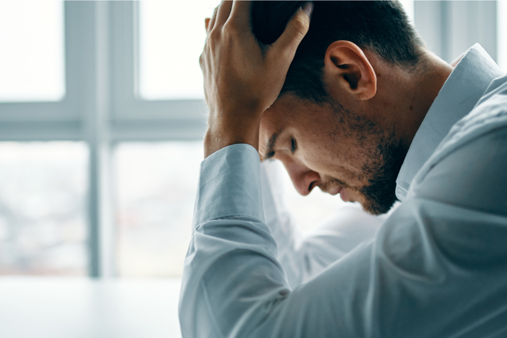 Stressed man with head in his hands