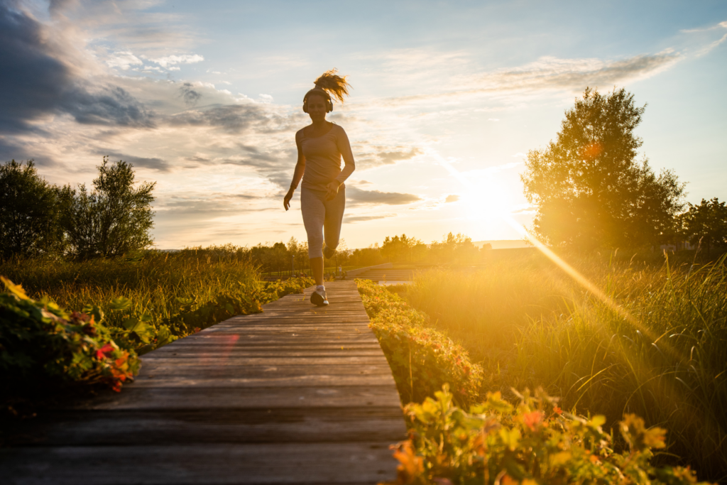 Woman running silhouetted against sunset
