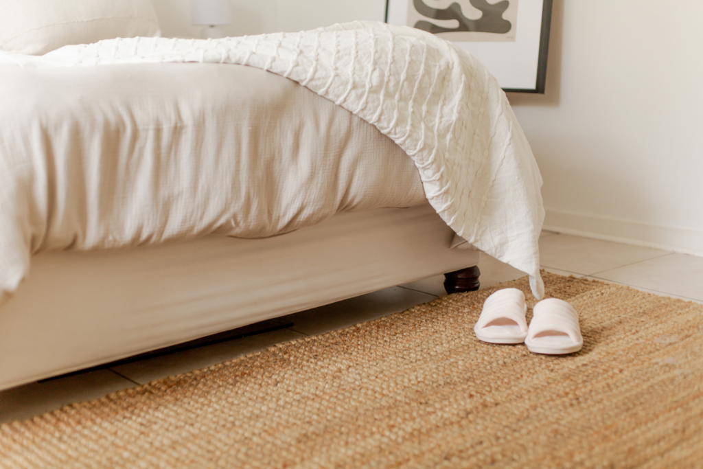 Cozy bedroom with slippers on the floor in morning sunlight