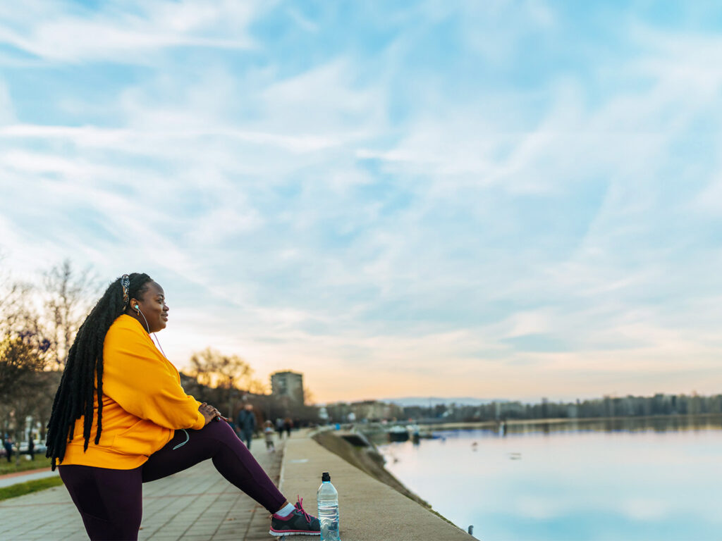 Woman stretching overlooking a lake