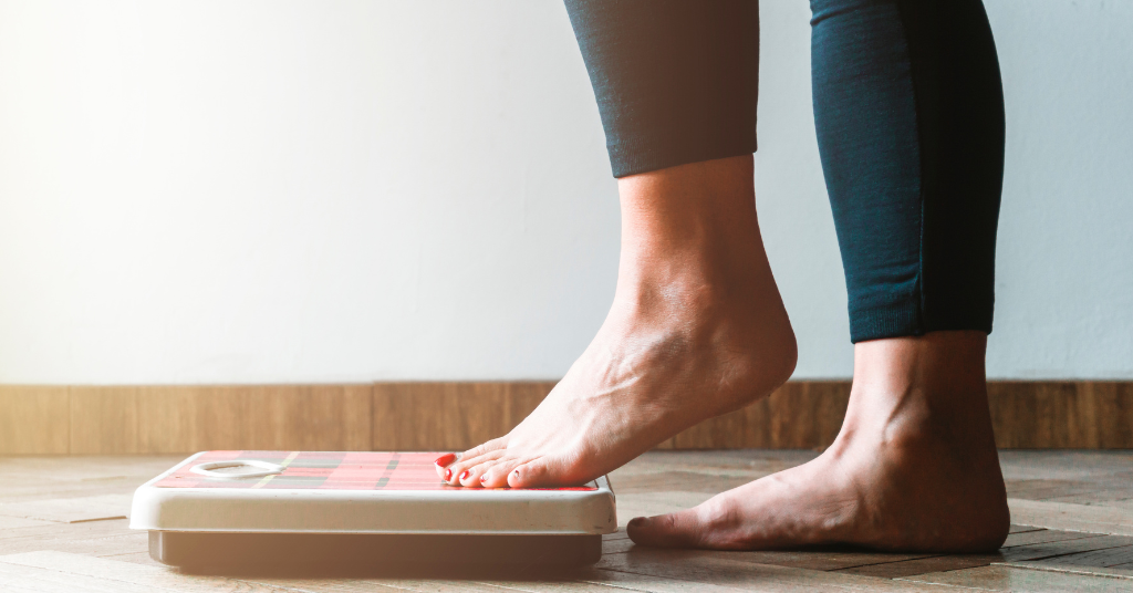 Woman stepping onto a scale.